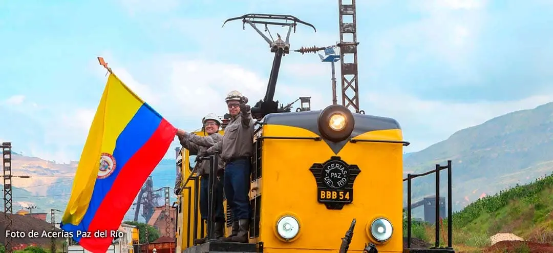 Trabajadores de Acerías Paz del Río con bandera de Colombia en el tren.