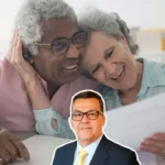 Pareja de adultos mayores sonríe leyendo documento junto a Jaime Dussán