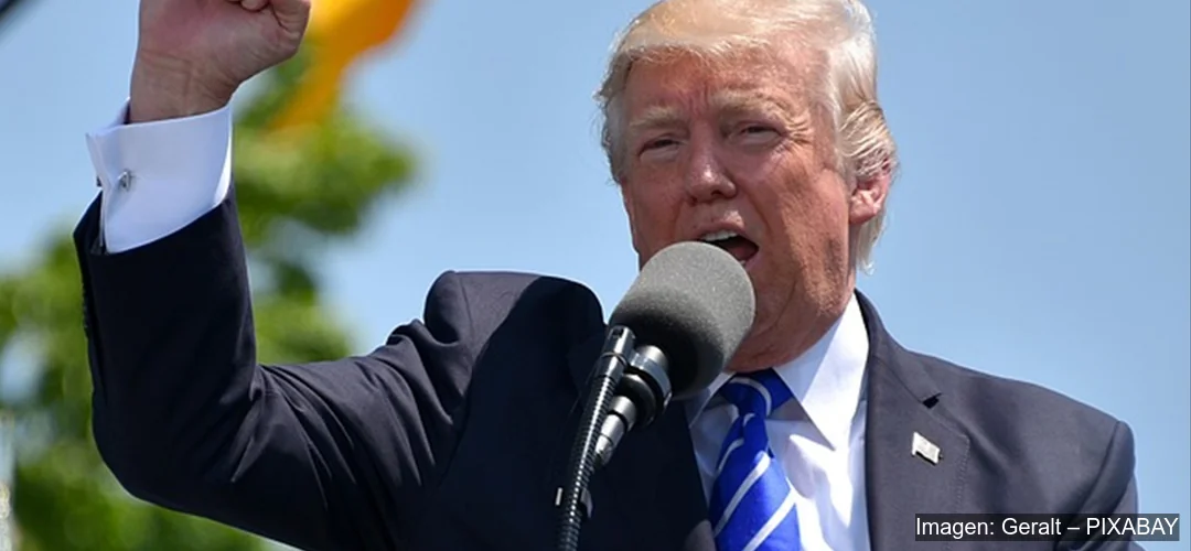 Donald Trump con micrófono y el puño alzado durante un discurso público sobre política comercial